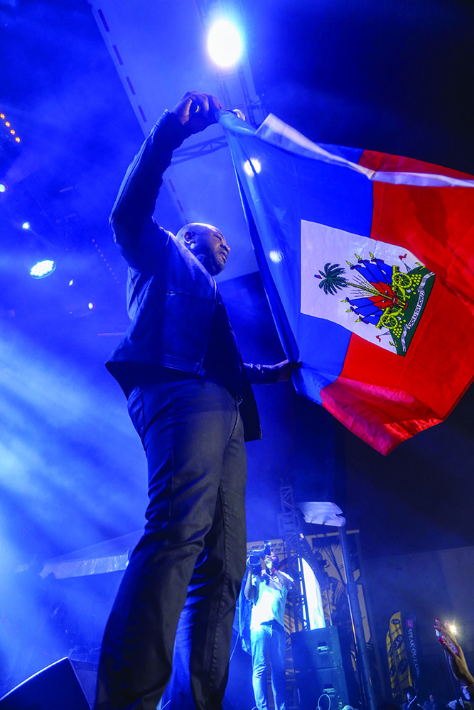 Arly Lariviere waving the Haitian Flag at the Haitian Compas Festival in Miami 2019